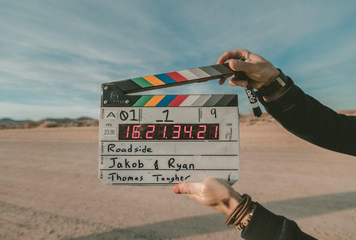 A clapperboard snapping shut against an open sky
