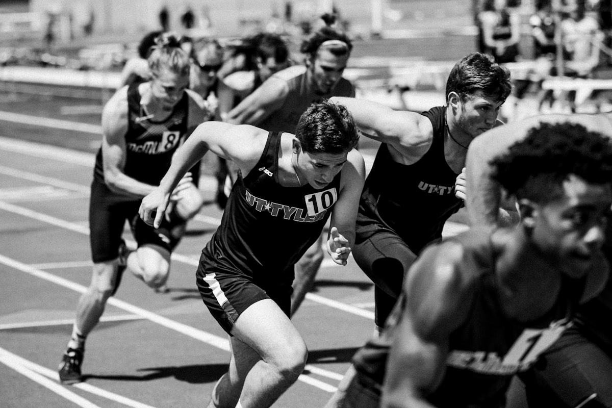 Sprinters exploding off the line, mid-race, in black and white